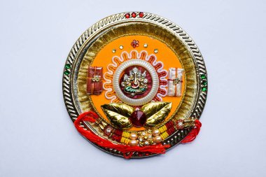 Beautiful Rakhi with Kumkum and Chawal sent to brothers on Rakshabandhan festival. Traditional puja thaali combo with Ganesha in center