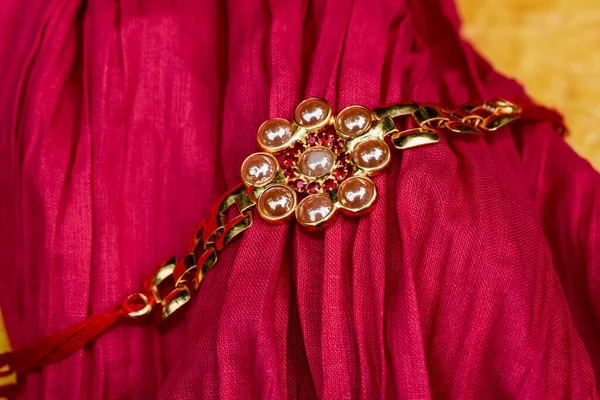 Rakhi Różowym Tle Materiału Złoty Pozłacany Bransoletka Rakhi Rakshabandhan Tkaniny — Zdjęcie stockowe