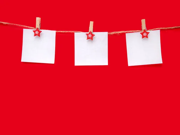Κόκκινο φόντο Χριστουγέννων. Τρία φύλλα χαρτί με χώρο για κείμενο σε σχοινί. Πάνω όψη, αντιγραφή χώρου — Φωτογραφία Αρχείου