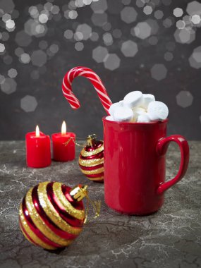 Sıcak kış içeceği: Marşmelovlu çikolata ve kırmızı bardakta karamel kamışı. Noel zamanı.