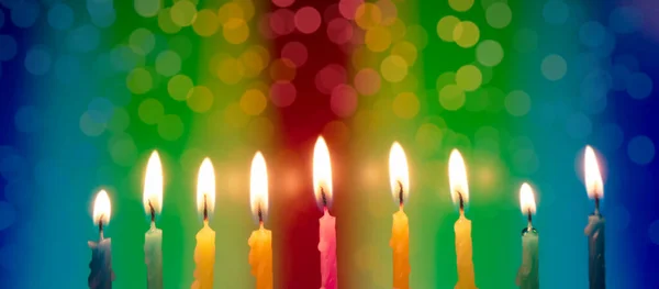 Hanukkah is a Jewish religious holiday of candles. Nine burning candles on bright multicolored background. fire festival — Stock Photo, Image