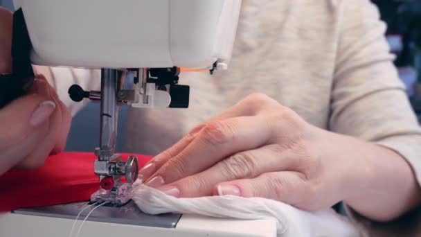 Le mani di una donna di mezza età cucire tessuto su una macchina da cucire moderna. Cucitrice al lavoro — Video Stock