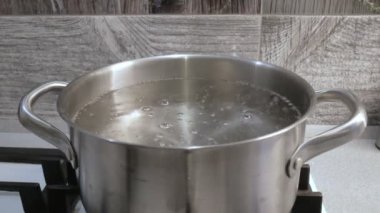 Gaz sobasında metal bir tavada kaynar su.