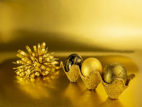 Elegante concepto de huevos de oro de Pascua. Huevos dorados de Pascua sobre un fondo dorado. Postal con espacio de copia —  Fotos de Stock