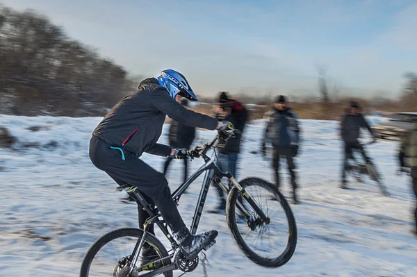 Велосипедист спускается со снежных гор — стоковое фото