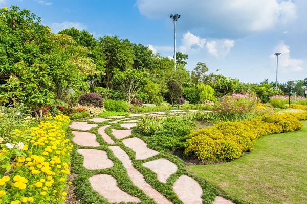 Kleurrijke bloemperken en kronkelende gras weg in een aantrekkelijke — Stockfoto