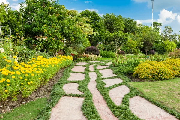 Kleurrijke bloemperken en kronkelende gras weg in een aantrekkelijke — Stockfoto