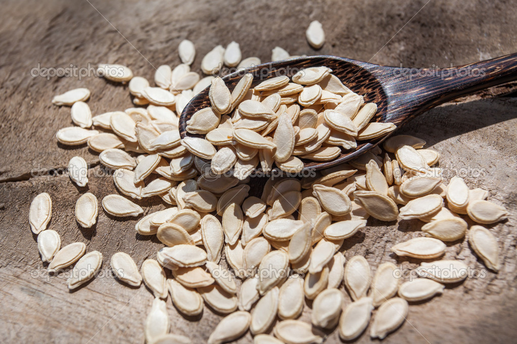 Wax gourd seeds on a wooden spoon — Stock Photo © tortoon 33676159