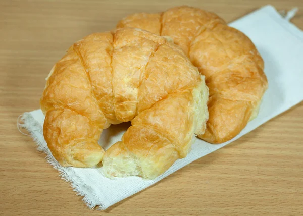 Snídaně s croissanty v koši na stole — Stock fotografie