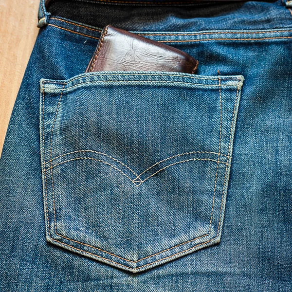 Blå jeans ficka med plånbok brun — Stockfoto