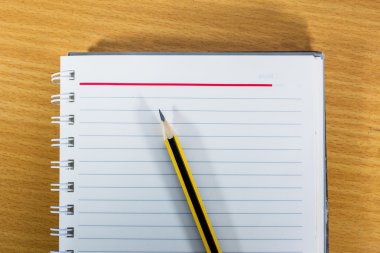 ahşap masa üstünde not etmek ve sarı kalem