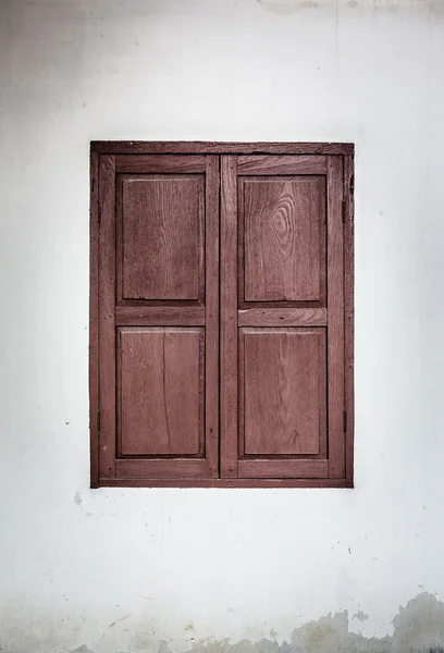 Ventana roja decorativa en una vieja pared de estuco blanco — Foto de Stock