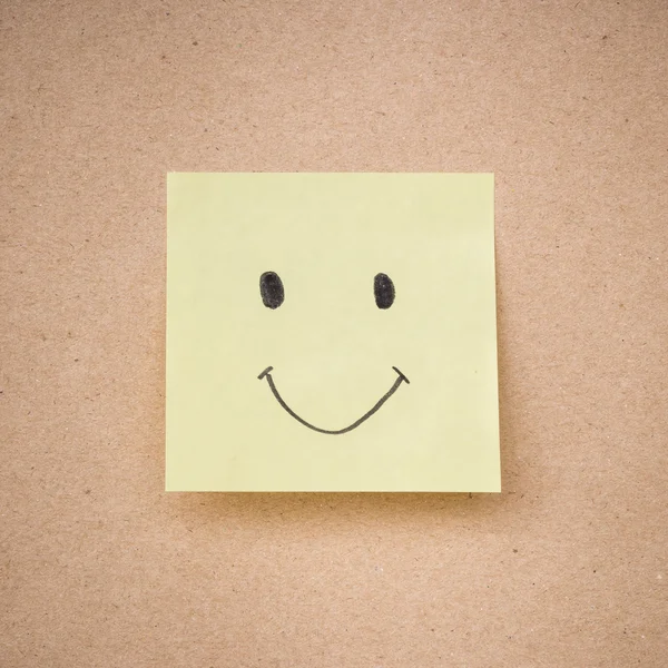 Sarı yapışkan not gülümsemek kahverengi kağıt dokusu üzerinde kapat — Stok fotoğraf