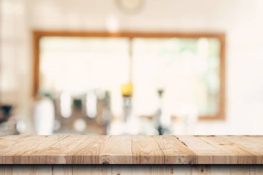 Kahvehanedeki bulanık insanlarla ahşap masa üstü ve ekran montajı için kafe arka planı, kopyalama alanı.
