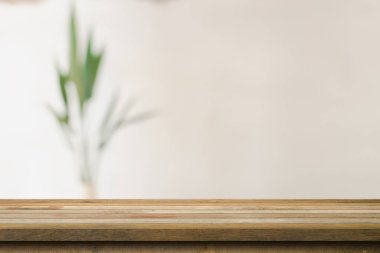 Wooden table top with blurred in coffee shop and cafe background for display montage, copy space.