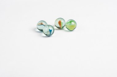 beyaz zemin üzerine cam mermerler