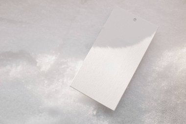 Boş hediye etiketi modeli. Karla kaplı arka planda kağıt etiket. Minimum kış hala hayattadır. Noel, mevsimlik indirim, indirim konsepti. Mevsimsel natürmort, seçici odaklanma. Damgalama.