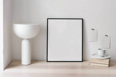 Kahvaltı hala hayattadır. Bir fincan kahve, ahşap masadaki kitaplar. Beyaz duvara bantlanmış boş not defterleri ve kart modelleri. Modern mermer masa lambası. Zarif İskandinav çalışma alanı, ev ofisi konsepti.