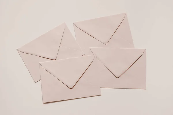 赤面ピンクの空白の封筒のモックアップの山。柔らかいヌードパステルの背景。郵送、対応およびポストの概念。ビジネス、オフィスの文房具、まだ生活。フラットレイアウト、トップビュー。ミニマルなウェブバナー. — ストック写真