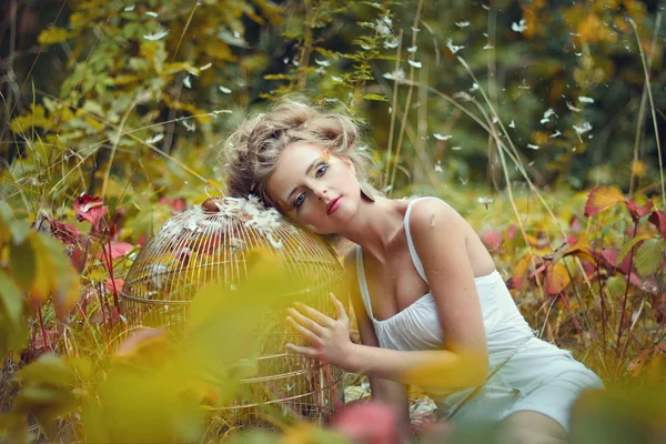 Hermosa chica de hadas con jaula de oro en un bosque —  Fotos de Stock