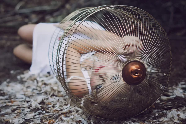 Menina loira bonita em uma gaiola dourada — Fotografia de Stock