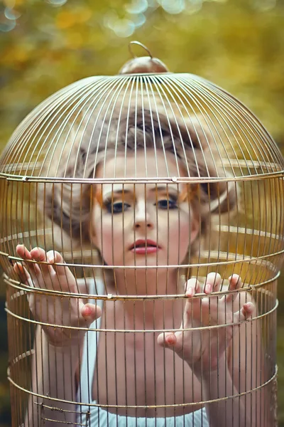 Menina loira bonita em uma gaiola dourada — Fotografia de Stock