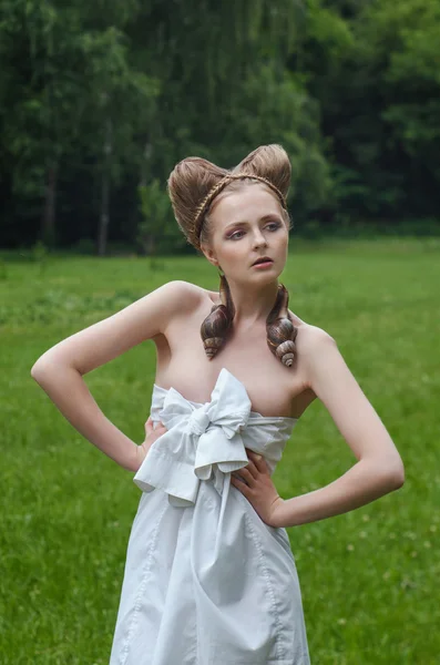 Nackte junge Frau mit Modefrisur und zwei großen Schnecken — Stockfoto