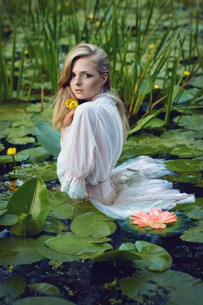 Beautiful girl stands in the middle of the pond with lotuses — Stock Photo, Image