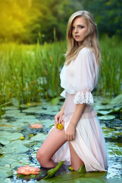 Hermosa joven con flores de loto — Foto de Stock