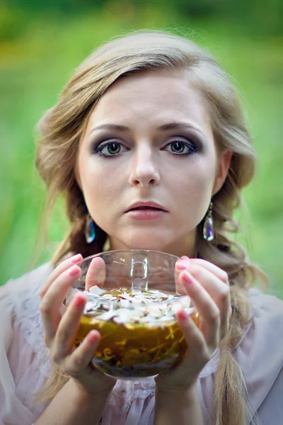 Mooi meisje met een kop van groene thee in haar handen — Stockfoto