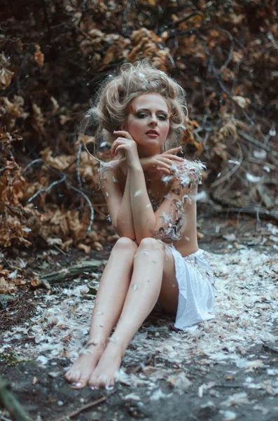 Gyönyörű meztelen lány az erdőben tollakkal — Stock Fotó