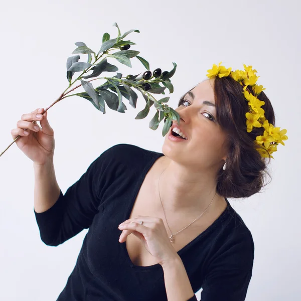 Красивая девушка с цветочным венком и оливковой ветвью — стоковое фото