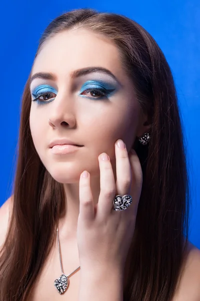 Красивая девушка с ярко-голубой макияж и ювелирные изделия — стоковое фото