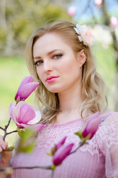 Vacker blond flicka bland våren blommande grenar magn — Stockfoto