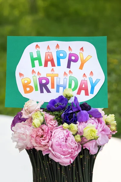 Bouquet of flowers and card Happy birthday — Stock Photo, Image