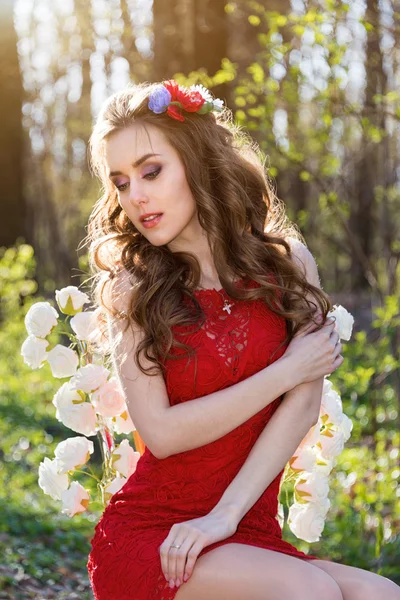 Gyönyörű fiatal nő, virágokkal a hajában az erdőben — Stock Fotó