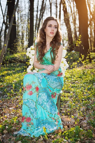 Hermosa joven con flores en el bosque — Foto de Stock