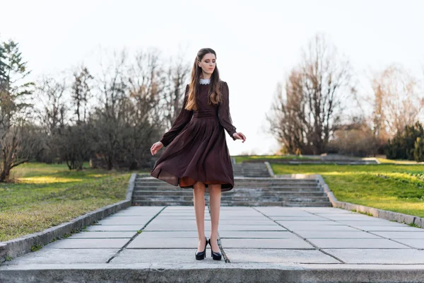 Young woman wearing a retro dress in the park — Stock Photo, Image