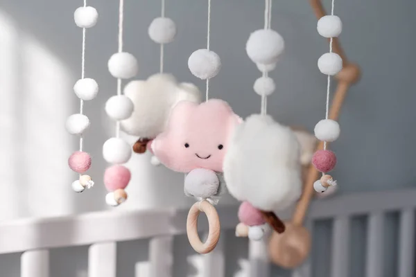 Łóżeczko dziecięce mobilne z uśmiechniętymi chmurami i śniegiem. Ręcznie robione zabawki nad noworodkiem. Pierwsze dziecko ekologiczne zabawki wykonane z filcu i drewna wiszące w pokoju światła — Zdjęcie stockowe