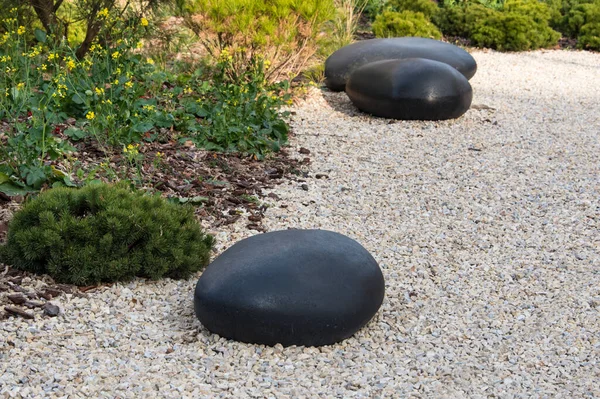 Zen garden dry landscape, or karesansui, japanese rock garden with black stones on white gravel for relaxation and concentration during meditation. Traditional Japanese temple settings — стоковое фото