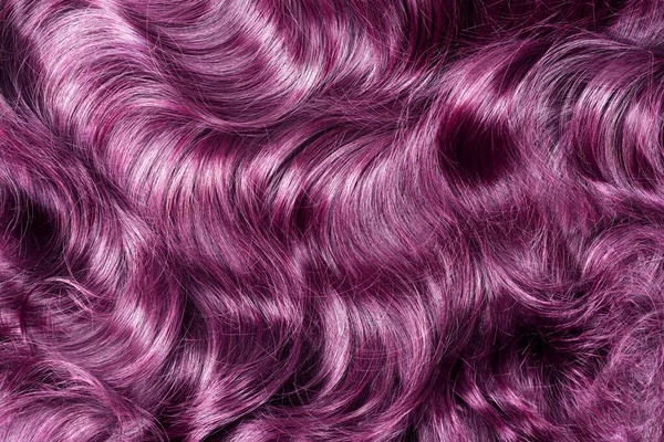 Lila haj textúra. Hullámos hosszú göndör lila vagy rózsaszín haj közel a háttérben. Hajhosszabbítás, anyagok és kozmetikumok, hajápolás. Hajviselet, hajvágás vagy haldoklás a szalonban. — Stock Fotó