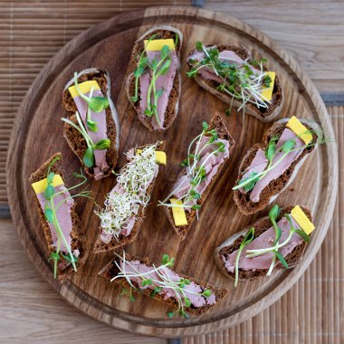 Wholegrain sandwiches with micro greens. Vegan party food table with organic vegetables canapes. Healthy lifestyle, modern cooking ingredients and eating right concept