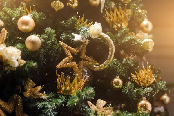 Weihnachtsbaum mit goldenen Sternen und Kronen geschmückt. — Stockfoto