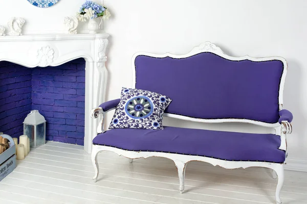 Wohnzimmer mit einem hellblauen Sofa sehr peri Farbe 2022. Kamin, Kerzen und Blumen, gemütliches Zuhause in trendigen Farben — Stockfoto