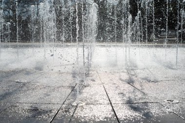 Sokaktaki çeşme. Güneşli bir günde su fışkırtan fıskiyeler. Seçici odak