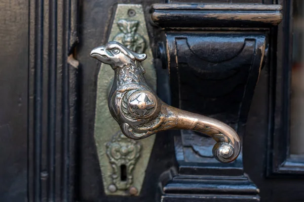 Stará klika. Dřevěné vchodové dveře se starožitnými klikami ve tvaru ptáka. Selektivní zaměření — Stock fotografie