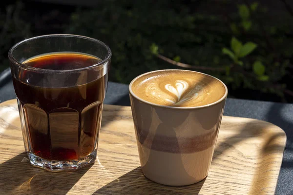 Twee Kopjes Koffie Houten Dienblad Met Latte Art Tafel Buiten — Stockfoto