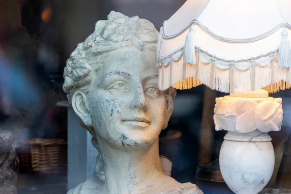 Antika kadın vitrindeki klasik lambanın yanındaki heykeli kırdı..