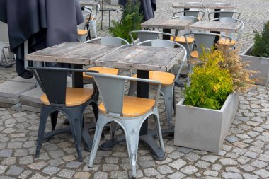 Empty table in outdoor cafe or restaurant. Tables and chairs at sidewalk cafe. Touristic setting, cafe table, sidewalk cafe furniture