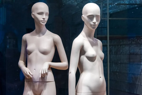 Naked female mannequins in the shop window. Fashion clothing woman mannequin in the store